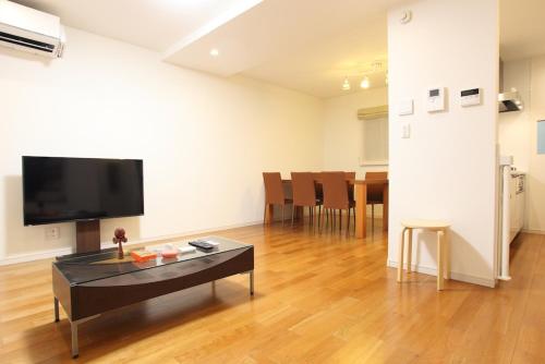 a living room with a table and a flat screen tv at 3LDK, Functional and New house in convenient Shinjuku in Tokyo
