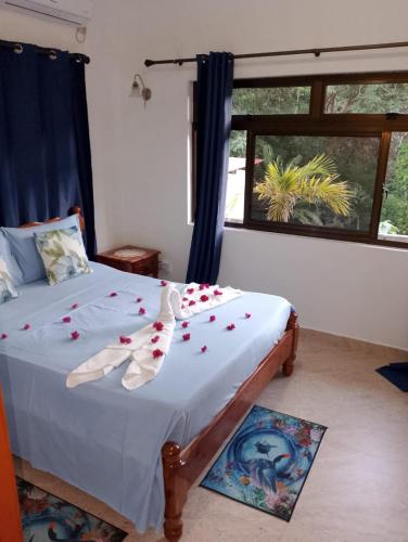 a bedroom with a bed with roses on it at Belle Rose Vue guest house in Baie Sainte Anne