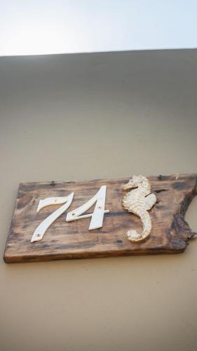 a wooden sign with two knives on a wall at Studios Piscina Privativa Pé na areia in Peruíbe