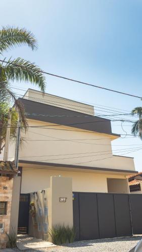 a house with a fence and a garage at Studios Piscina Privativa Pé na areia in Peruíbe