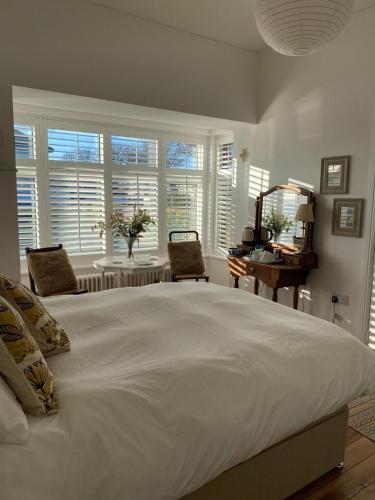 a large white bed in a room with windows at 7 Goathill Crescent in Stornoway
