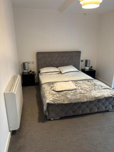 Un dormitorio con una cama grande con un cabecero grande. en One Bedroom Apartment in Greenwich Peninsula, en Moffat