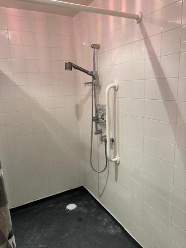y baño con ducha y azulejos blancos. en One Bedroom Apartment in Greenwich Peninsula, en Moffat