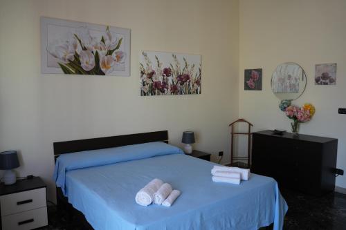 - une chambre avec un lit bleu et 2 serviettes blanches dans l'établissement La Regina del Sole, à Reggio de Calabre