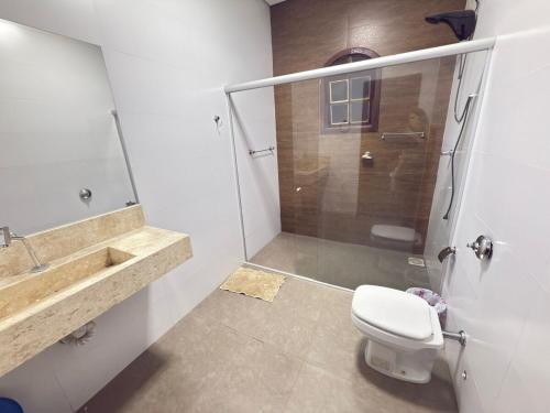 een badkamer met een douche, een toilet en een wastafel bij CasaBela in Juatuba