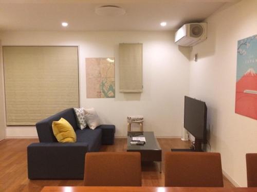 a living room with a blue couch and a tv at 3LDK, Functional and New house in convenient Shinjuku in Tokyo