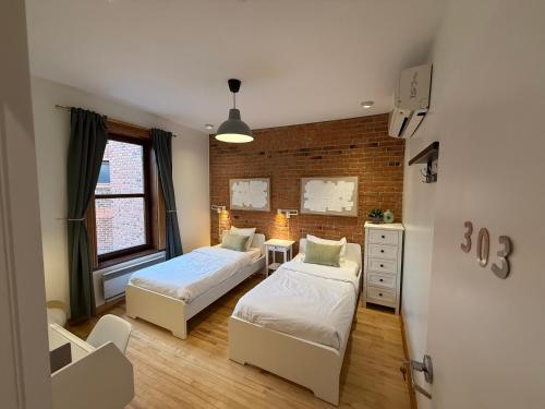 a bedroom with two beds and a chair in it at Auberge du Plateau in Montréal