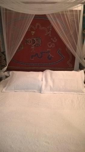 1 dormitorio con cama con dosel y sábanas blancas en Ocean apartment, en Río de Janeiro