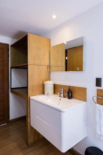 a bathroom with a white sink and wooden cabinets at Elite Maya Hotel & Spa in Antigua Guatemala