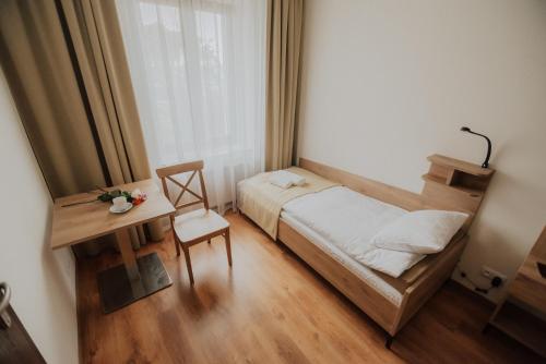 Un dormitorio pequeño con una cama y un escritorio. en Dom Jańskiego, 