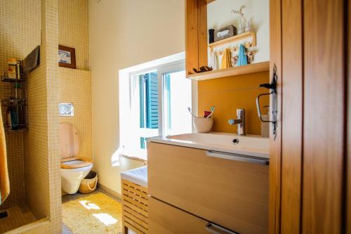 a bathroom with a sink and a toilet at Casa do Mar - Familiar T3 Duplex - Terraço - Central in Nazaré