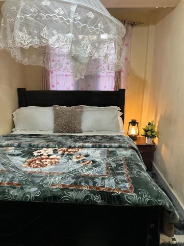 Un dormitorio con una cama con una colcha floral. en Haus Cossie, en Machakos