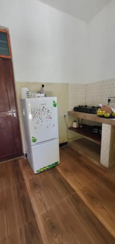 a kitchen with a white refrigerator with magnets on it at Nionje Garden Villa in Jambiani