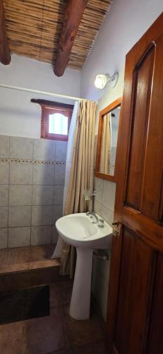a bathroom with a white sink and a window at Tierra Norte - Cabañas in Tilcara