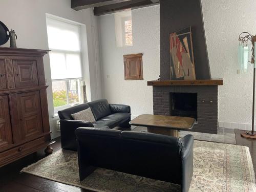 Una sala de estar con un sofá y una chimenea. en Solwerderstraat 12 - Hangende Keuken, en Appingedam