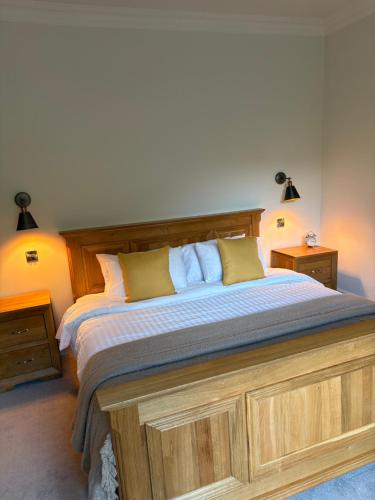 Un dormitorio con una cama grande con cabecero de madera. en The Boyne Arms, en Burwarton