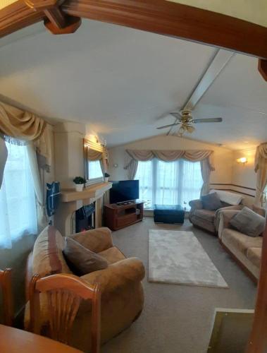 a living room with couches and a ceiling fan at i7 Millfields 6 Berth Luxury Caravan DG & GCH Familys Only And Lead Person Must Be Over 30 in Ingoldmells