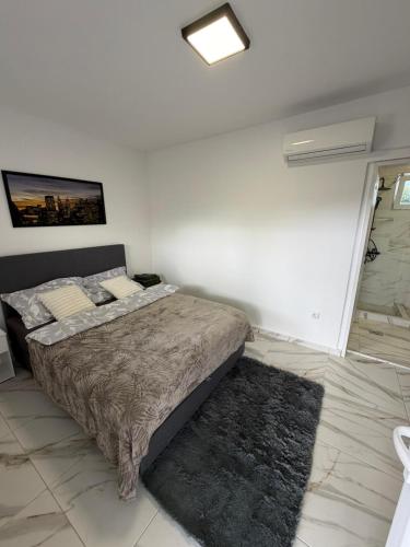 Un dormitorio con una cama en una habitación blanca. en Lokal za zurke, slavlja i rodjendane, en Pećinci