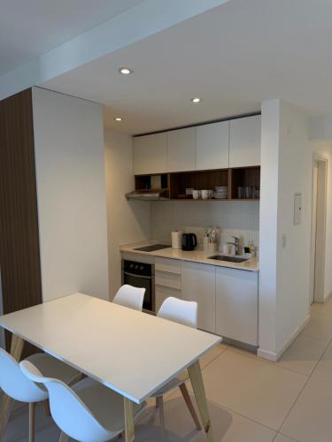 a kitchen with a white table and chairs at Segundo hogar in Luján