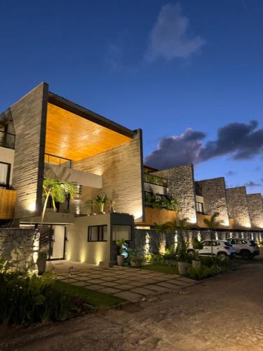 una casa con la fachada iluminada por la noche en Triplex Nalu - Sofisticação na Rota Ecológica de Milagres, en Porto de Pedras