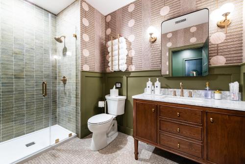 a bathroom with a toilet and a shower and a sink at Hollyhock Suite 505 in Louisville