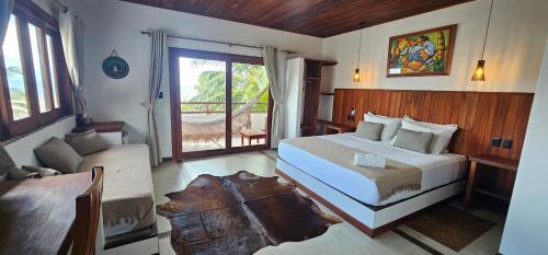 a bedroom with a bed and a living room with a window at Upwind Villas Boutique - Praia de Maceió - Camocim - CE in Maceio