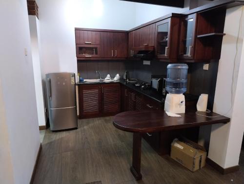 a kitchen with wooden cabinets and a table with a blender at Eldorado Apartments 3BR Apart No F2P3 in Alwis Town