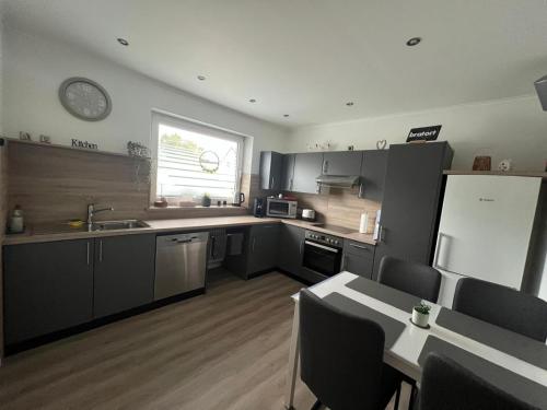 a kitchen with gray cabinets and a sink and a window at Ferienwohnung Dammer in Niederkrüchten