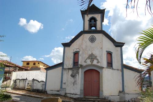 an old church with a tower and a red door at Pousada Rainha dos Anjos in Mariana