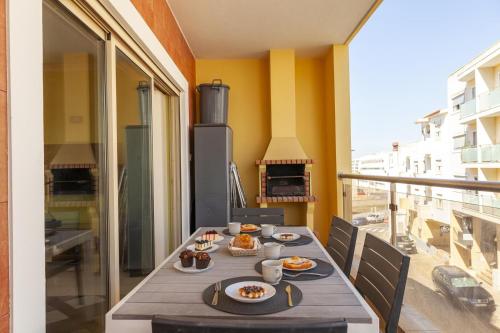 a table with plates of food on a balcony at Patio do Convento Apartments in Lagos