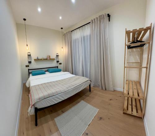 Un dormitorio con una cama con almohadas azules y una escalera en Urban Oasis Studio, en Ereván