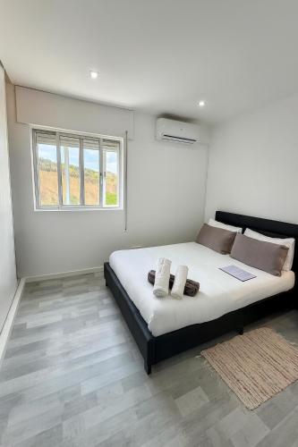 a bedroom with a large bed with two pillows at StaySanto in Loures in Loures
