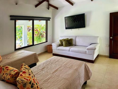 a living room with a couch and a tv at Espectacular finca cerca a Buga in Guacarí