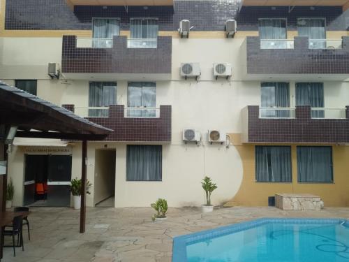 un hotel con piscina frente a un edificio en Hotel Solemio, en Aracaju