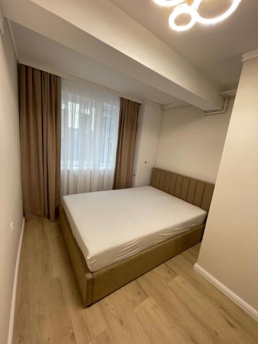クルジュ・ナポカにあるIulius Cluj Apartamentのベッドと窓のある小さな寝室