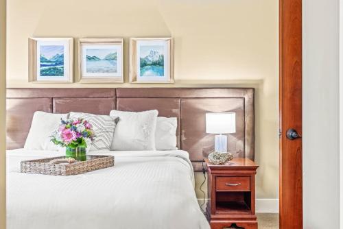a bedroom with a bed with a vase of flowers on it at Cozy 2BR Retreat Mountain View with Pool and Hot Tub in Canmore