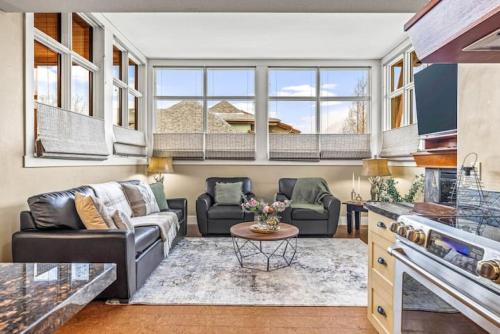 a living room with a couch and a table at Cozy 2BR Retreat Mountain View with Pool and Hot Tub in Canmore