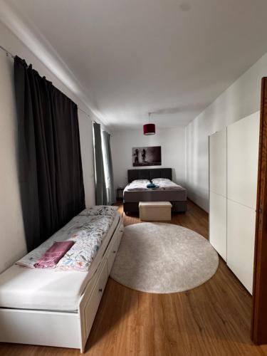 a bedroom with two beds and a rug at Aby Wohnungen in Rosenheim
