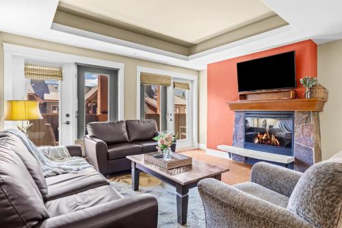 ein Wohnzimmer mit Sofas und Kamin in der Unterkunft Spacious Rockies Escape near Banff Hot tub and Gym in Canmore