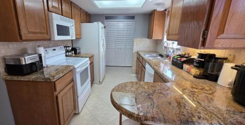 a kitchen with wooden cabinets and a white refrigerator at Hot Tub, Game Room, Kayaks, Boat Parking, Backyard, King, Fire Pit, Pets, WD in Page