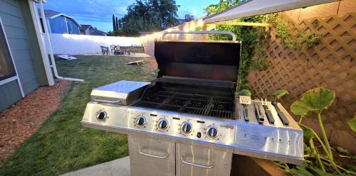 a barbecue grill sitting on the side of a backyard at Hot Tub, Game Room, Kayaks, Boat Parking, Backyard, King, Fire Pit, Pets, WD in Page