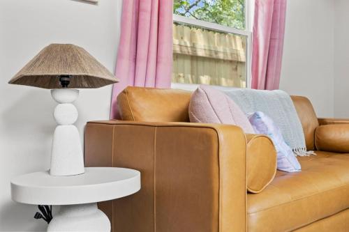 a living room with a couch and a table with a lamp at River Run - Riverfront Tiny Home, Trails, and Views! in Sylva