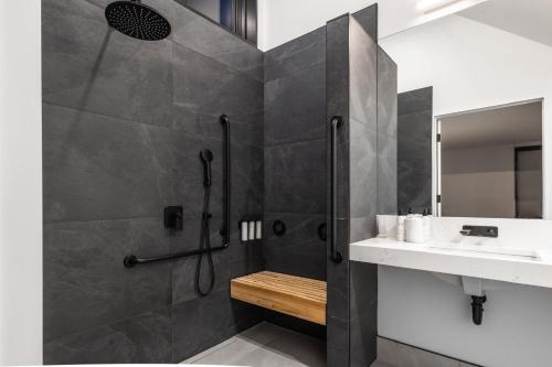 un bagno con doccia e lavandino di Juniper - Accessible Luxury Cottage with Stunning Views, Private Hot Tub, Private Path to Beach a Chimney Corner