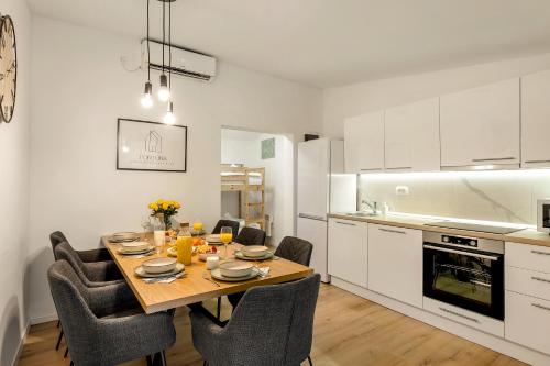 a kitchen with a table and chairs in a kitchen at Superior Holiday Home Fortuna in Čatež ob Savi