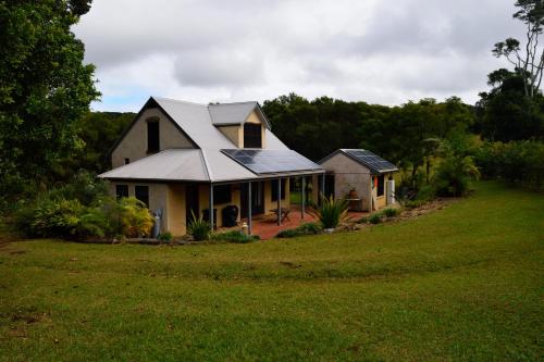 a house with a roof on top of a field at The Barn in Bangalow
