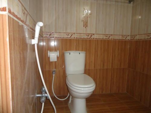 a bathroom with a toilet with a hose at Muscat Holiday Resort in Cox's Bazar