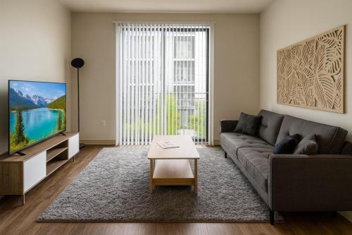 a living room with a couch and a tv at Central Birmingham Stylish Midrise Unit in Birmingham