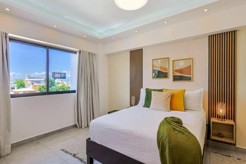 a bedroom with a large bed and a large window at Cozy 1BR Condo, Pool, Gym in Ensanche Quisqueya