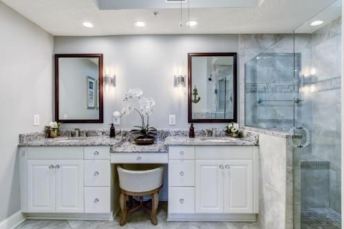a bathroom with two sinks and a shower at Enjoy Oceanfront Luxury and Magical Sunrises at this 2-bedroom 2-bath condo in Amelia Island