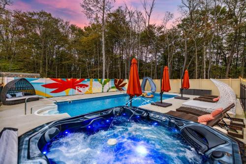 a hot tub in a backyard with umbrellas at The Poconest - Luxurious Mountain Mansion in Long Pond